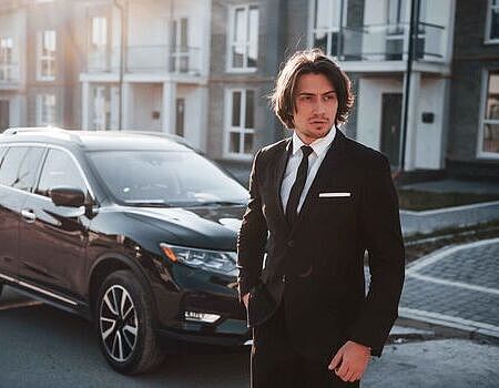 portrait-handsome-young-businessman-black-suit-tie-outdoors-near-modern-car-city_1